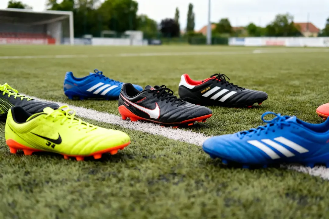Chaussures de football variées sur un terrain Unisport en gazon synthétique