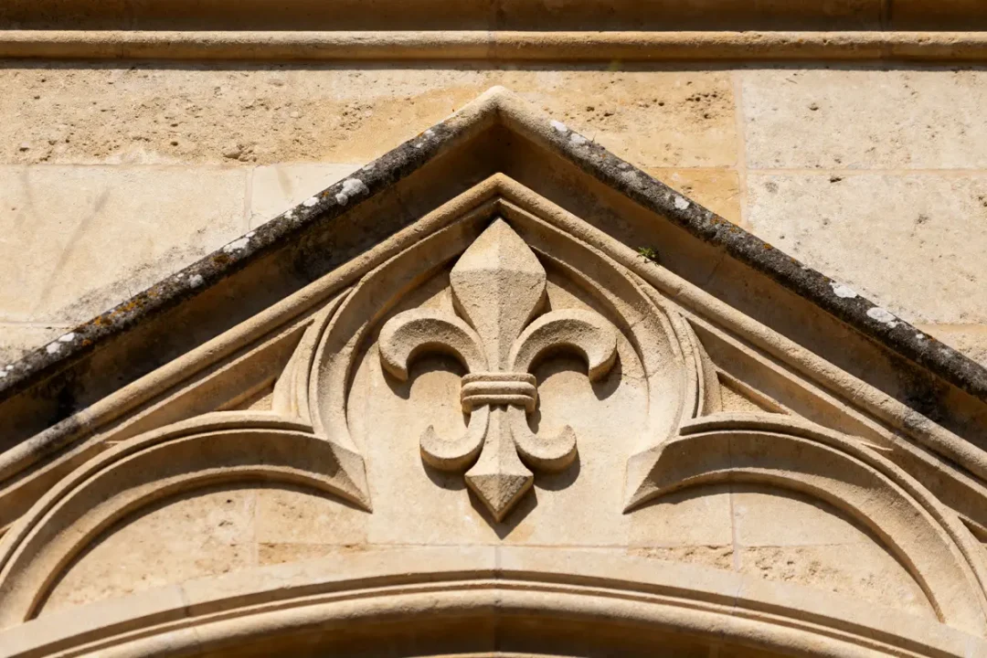 Ornement architectural en pierre sculpté, représentant une fleur de lys, synonyme de clé de voûte