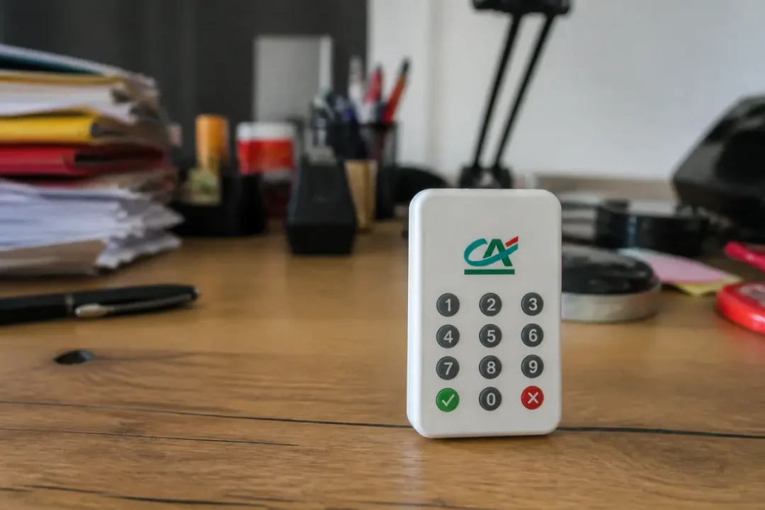 Clavier numérique du Crédit Agricole, pour authentification, posé sur un bureau encombré.